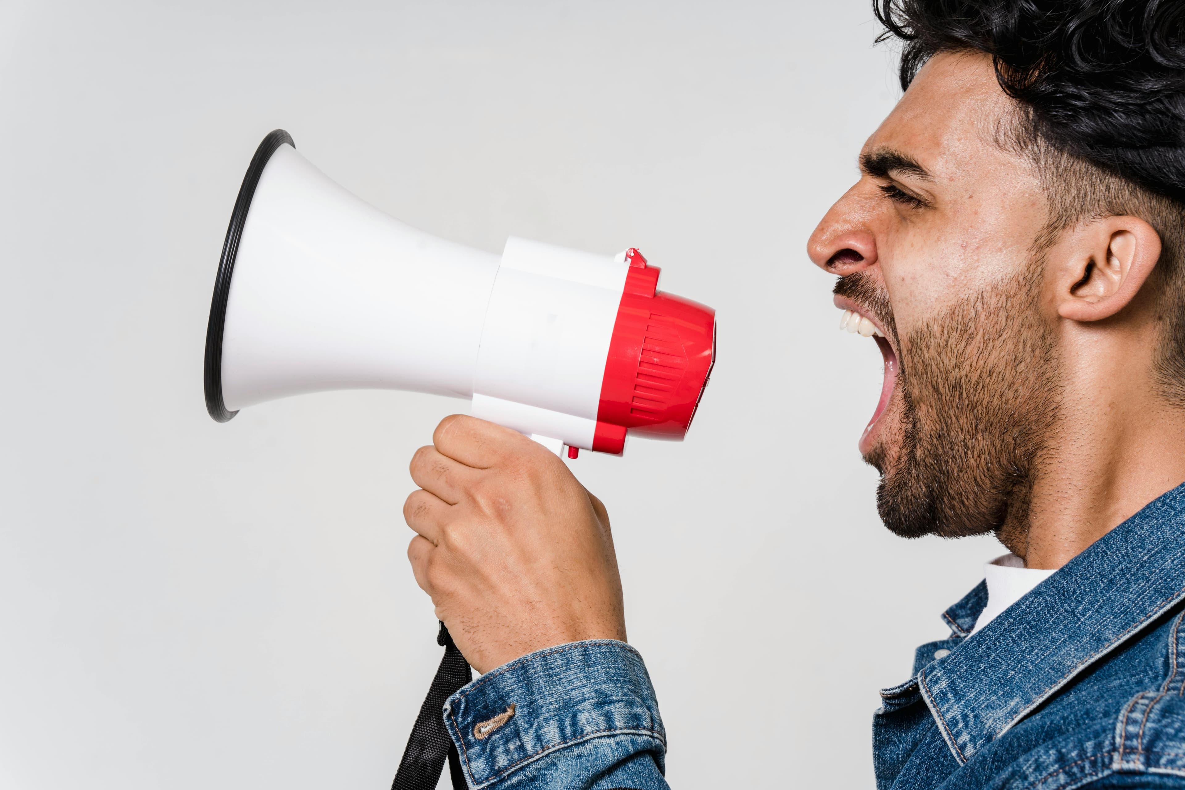 Homme criant dans un mégaphone, illustrant le niveau sonore élevé mesuré en décibels.